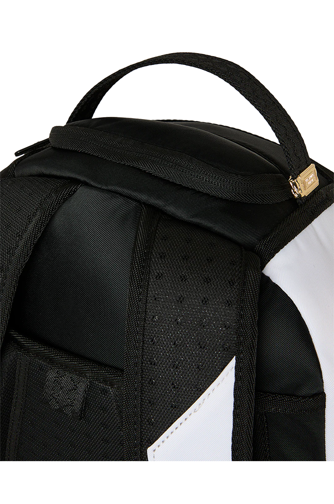 Close-up of a black backpack showing the top handle, padded shoulder area, side pocket, and a white side panel with a small gold zipper pull.