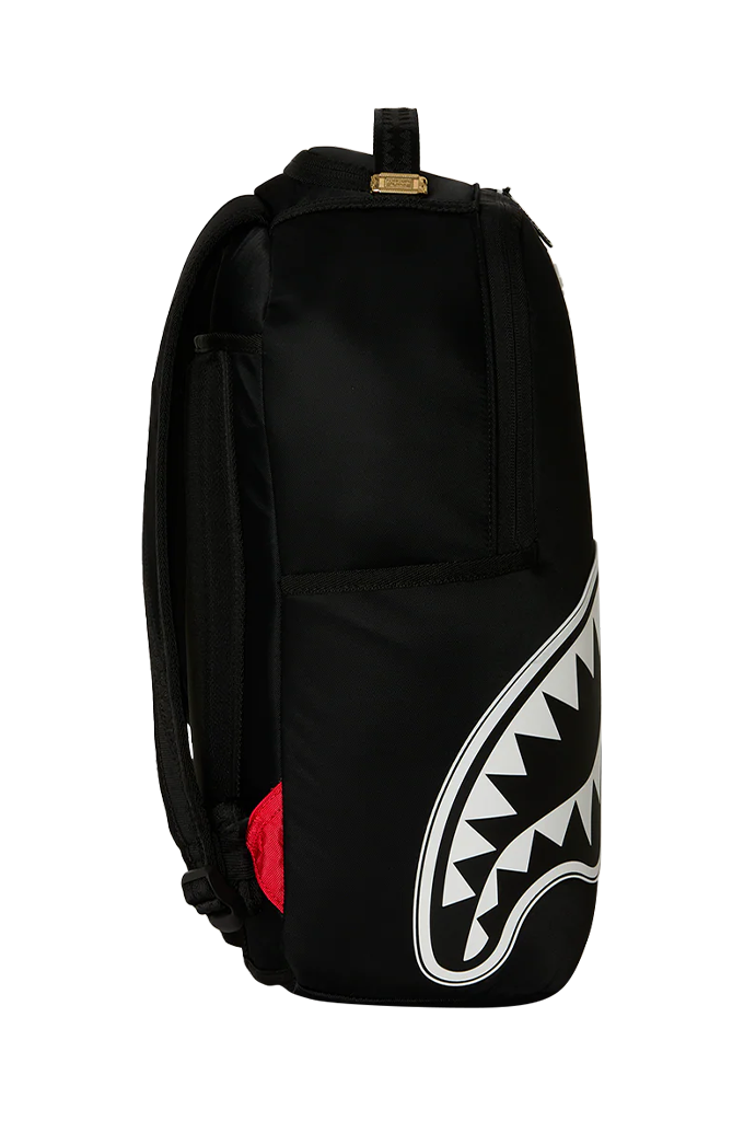 A black backpack featuring a large white shark mouth graphic on the lower right side and a small red accent on the lower left, shown against a plain white background.