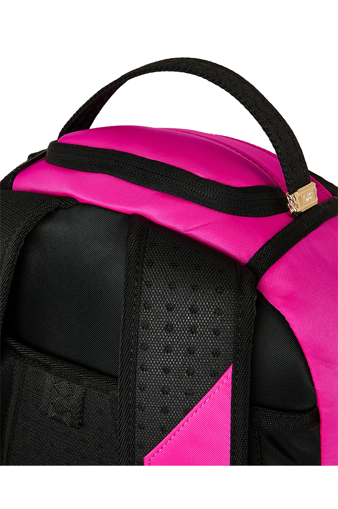 Close-up of a backpack showing a bright pink and black color-blocked design, with a black top handle, black mesh ventilation panel, and a small gold zipper pull on a white background.
