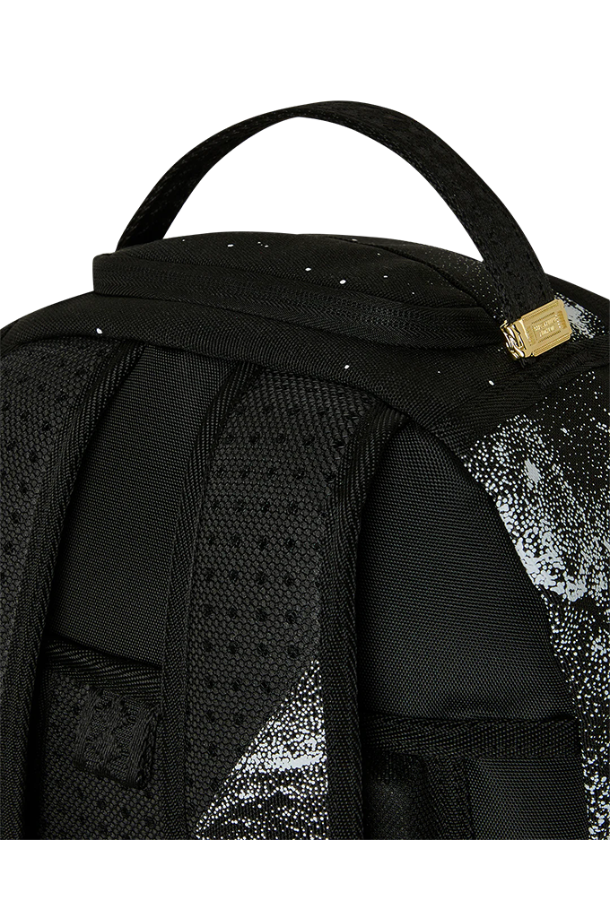 Close-up of the back of a black backpack with a textured honeycomb pattern, a top carry handle, and a small gold brand plaque.