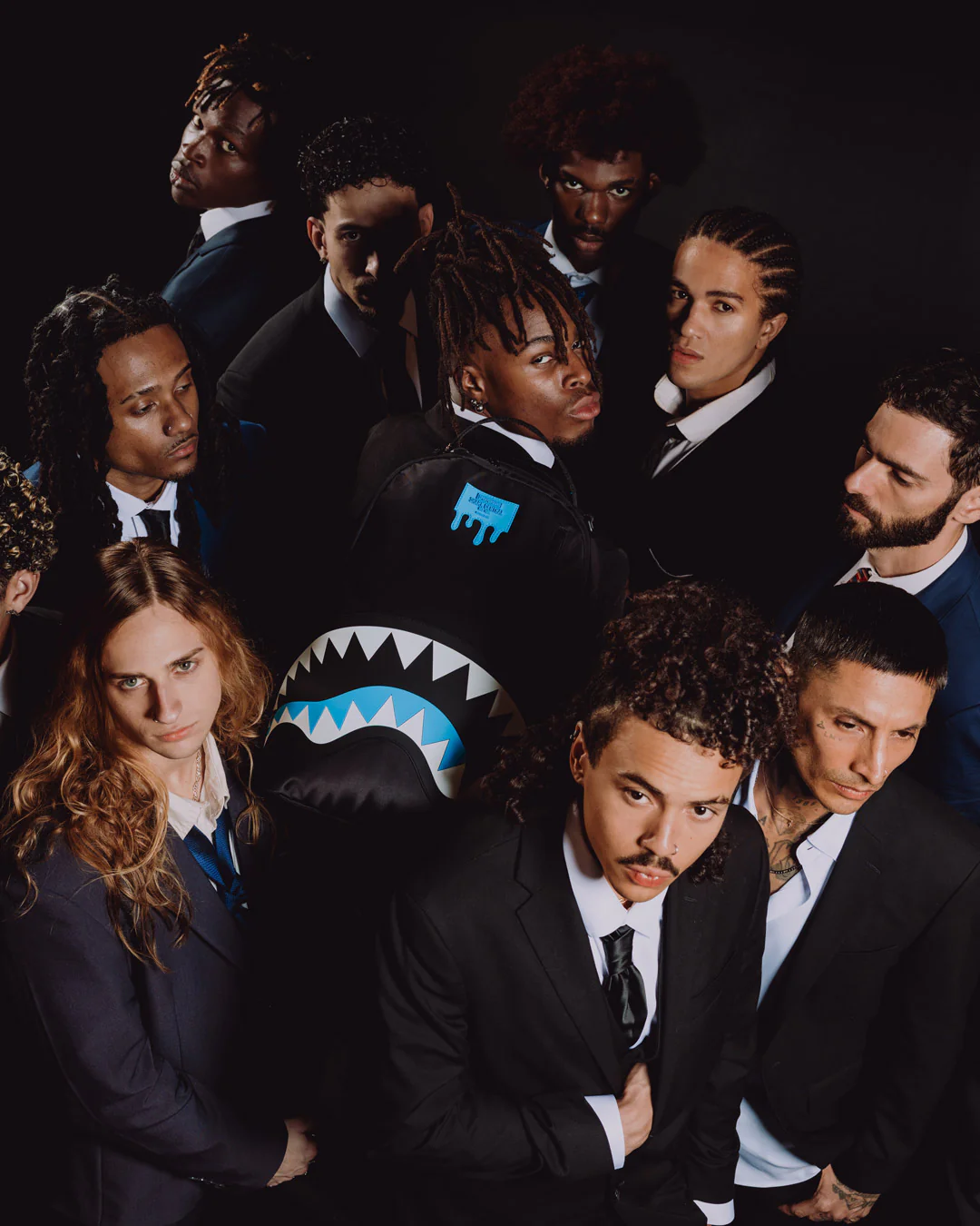 Group of people in formal attire with one person wearing a shark-themed jacket.