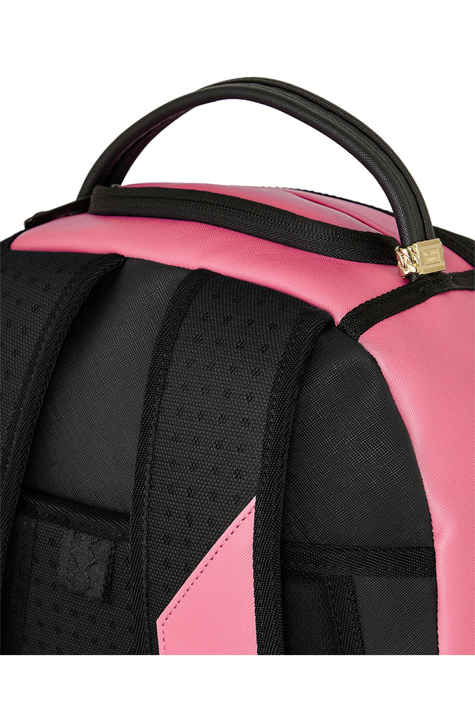 Close-up of a pink and black backpack showing the top handle, zipper with a gold-tone pull, padded shoulder straps, and fabric texture on a white background.