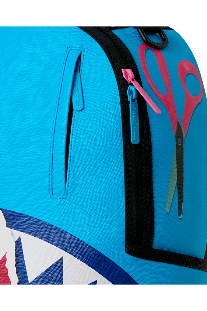 Close-up of a bright blue backpack featuring a black zipper pocket with a pink zipper pull, a side slip pocket, and a graphic of pink scissors on the front.