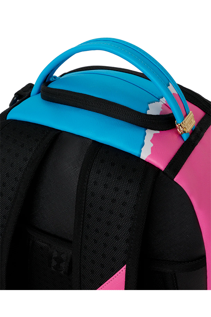 Close-up of a backpack showing the top handle, black padded shoulder straps, and bright pink and turquoise side panels with a small gold zipper pull.