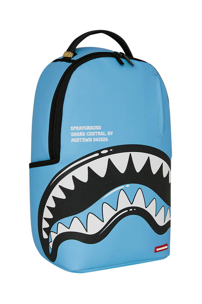 A light blue Sprayground Shark Central backpack featuring a large shark mouth graphic with white and black teeth, black zippers, and a top handle.