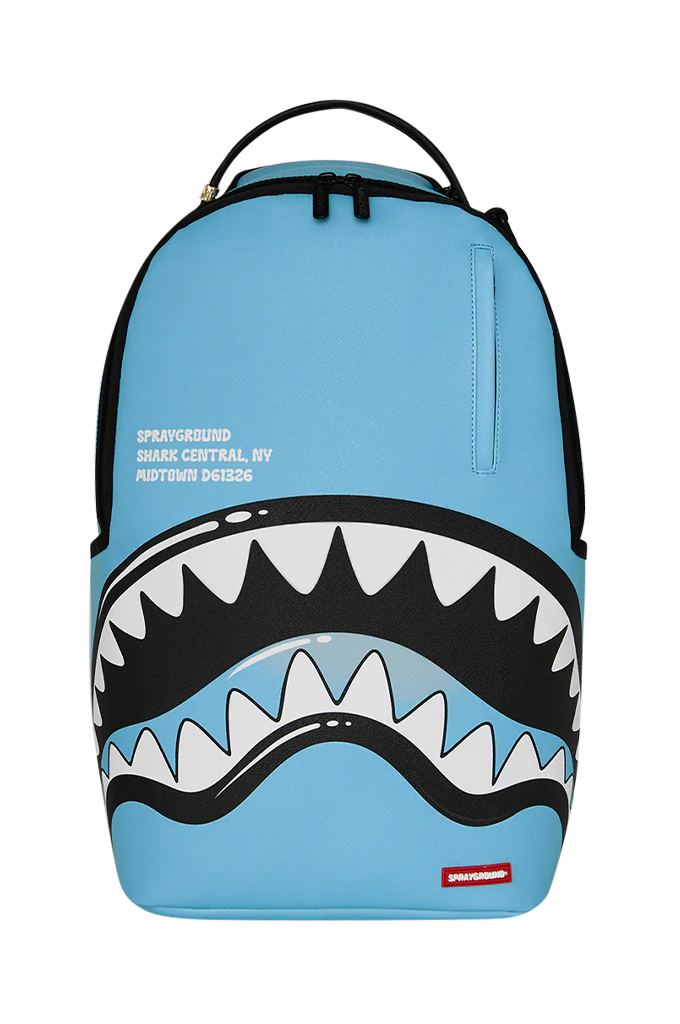 A light blue Sprayground Shark Central  backpack featuring a large shark mouth graphic with black, white, and gray teeth across the lower front, plus a top carry handle and zip closure.