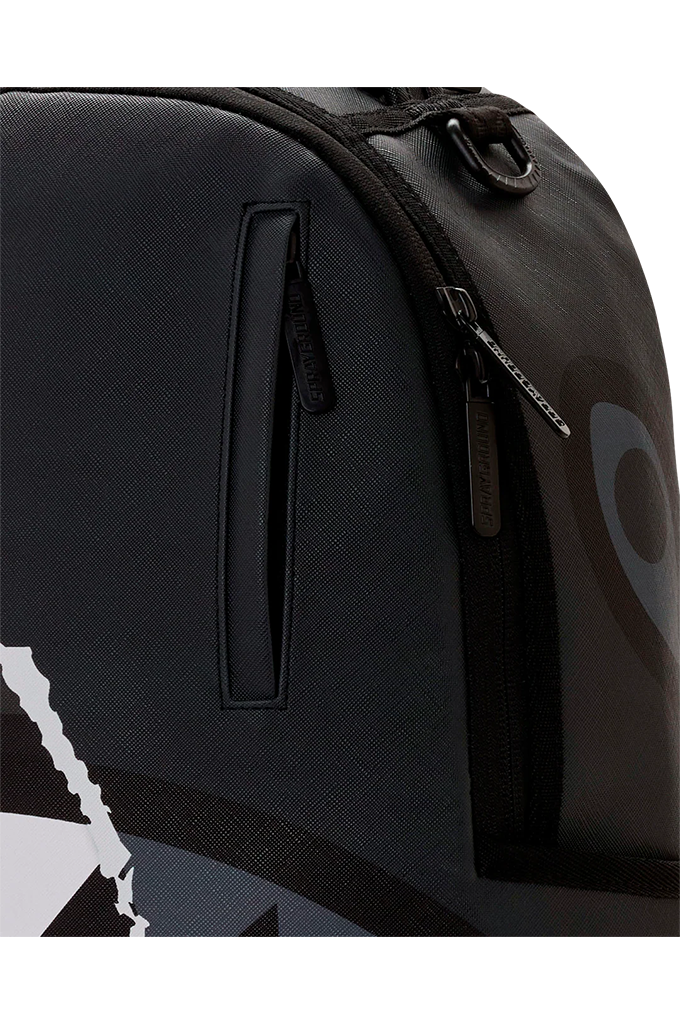 Close-up of a black backpack with a vertical zippered pocket and a dark gray graphic print on the side, featuring a visible Peak Design zipper pull.