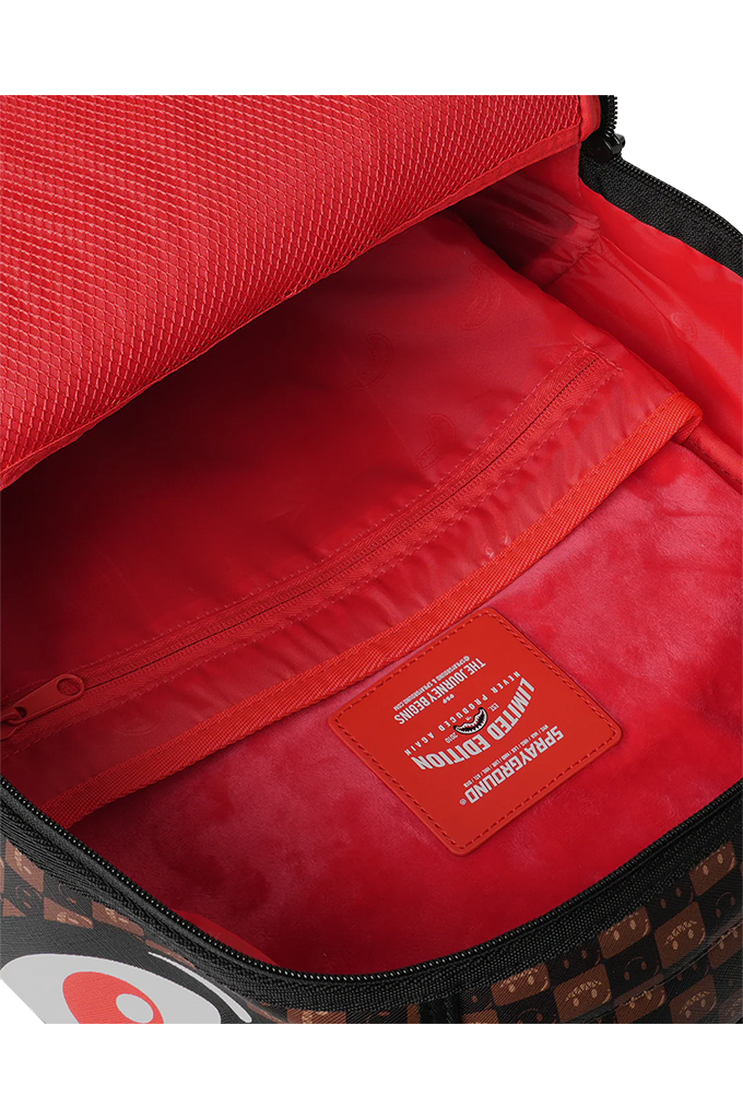 Close-up of the interior of a red backpack, showing a red zippered pocket with a brown brand patch that reads 'LIMITED EDITION'.