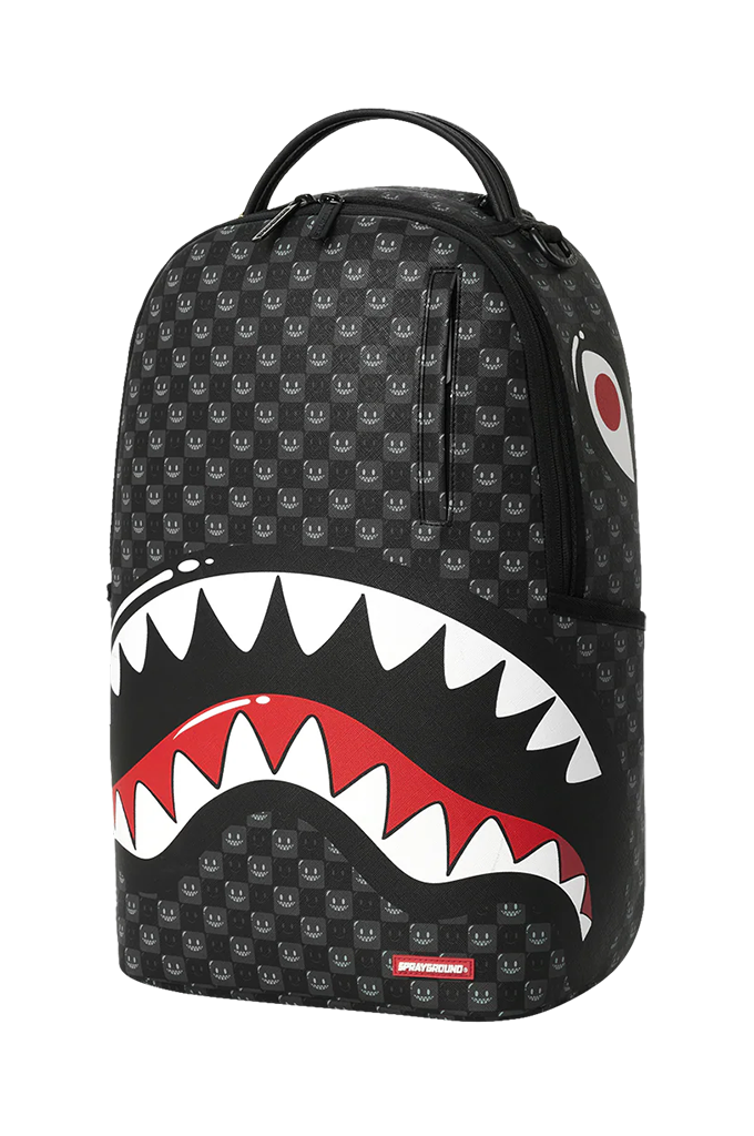 A black backpack featuring a repeating shark-face pattern, with a large open shark mouth graphic in white and red on the lower front, plus a top carry handle.