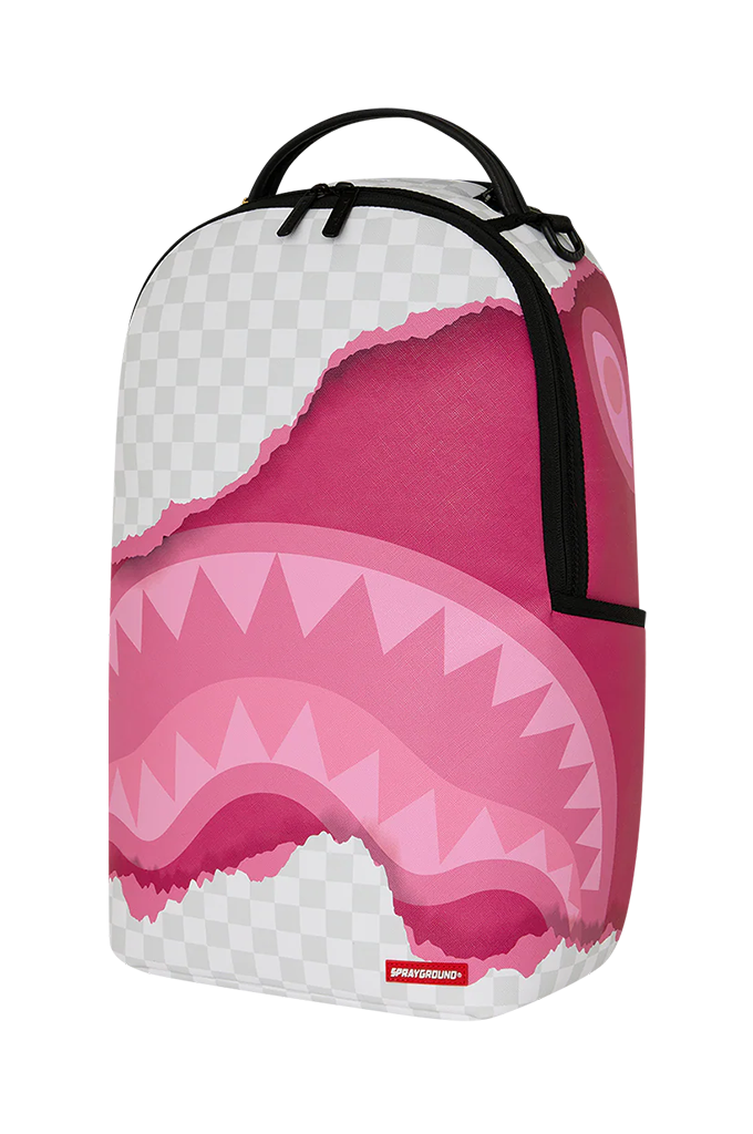 A Sprayground backpack featuring a pink shark mouth graphic with white and pink tones, black straps, and a visible Sprayground logo patch at the bottom.