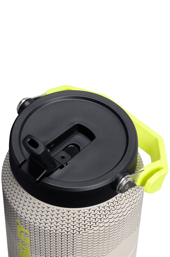 Close-up of a cylindrical insulated tumbler with a textured light gray body, black lid, and bright neon yellow-green carrying handle on a white background.#color_sahara-hypergrip