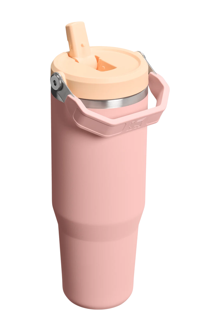 A tall, insulated tumbler in dusty pink with a light peach-beige lid and carry handle, featuring a stainless steel rim and a flip-up straw, shown on a solid white background.#color_peach-rose