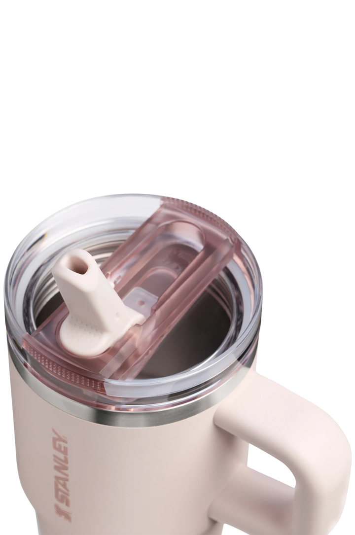 Close-up of a Stanley insulated tumbler with a handle, clear lid, and translucent pink lid insert on a white background.#color_rose-quartz