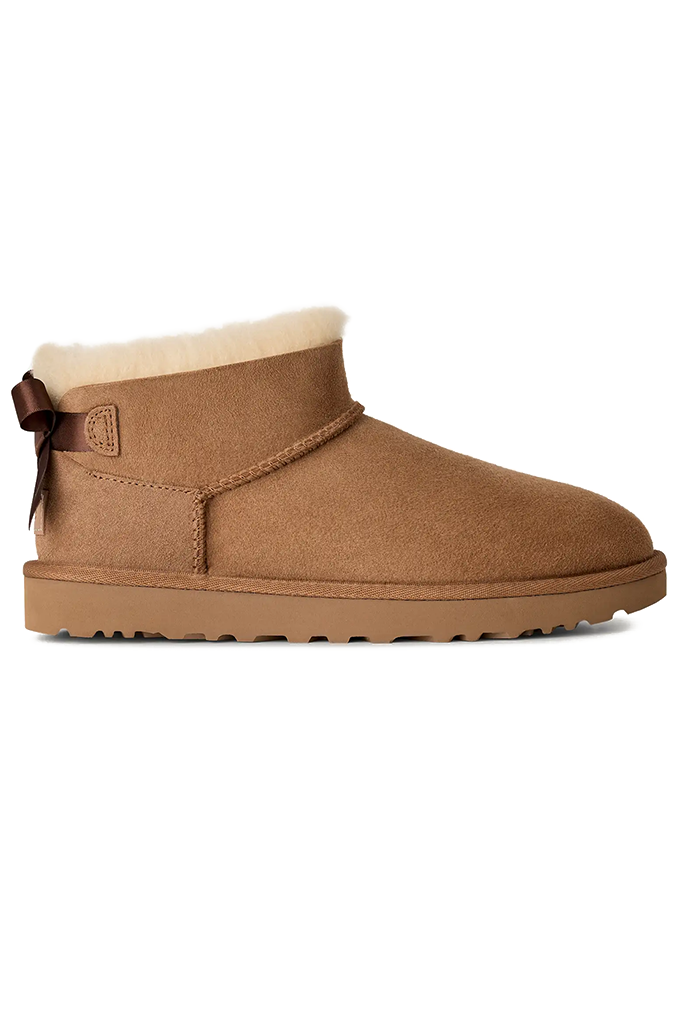 A single brown suede slipper boot with a cream-colored shearling lining, shown from a side profile view against a plain white background.
