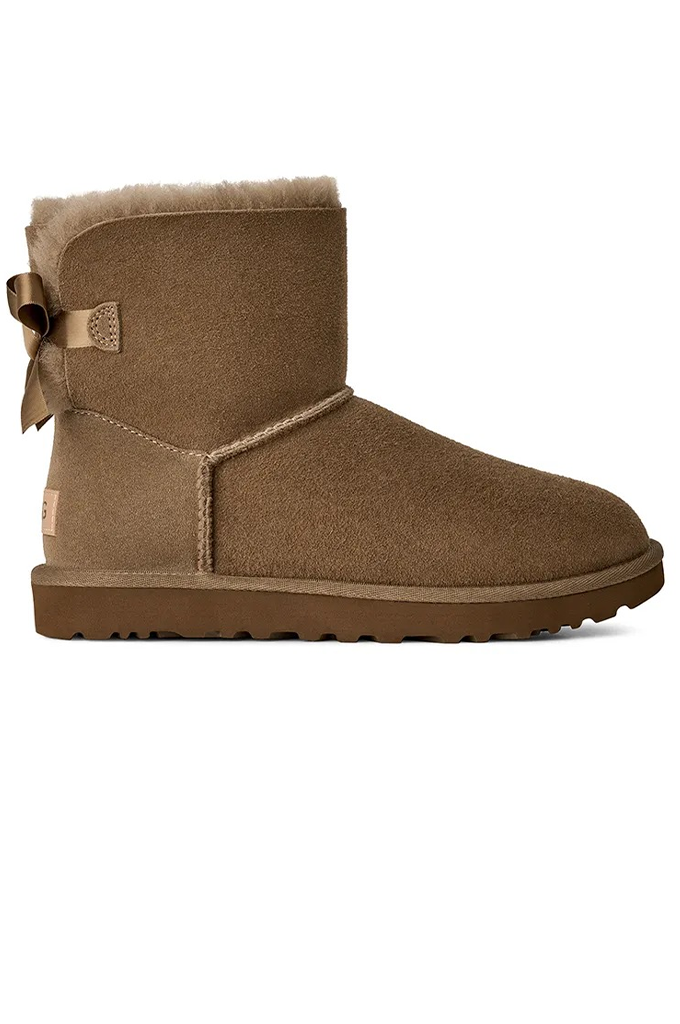 A single brown suede ankle boot with a matching bow detail on the side and a soft shearling lining visible at the top, shown against a plain white background.#color_light-bronze