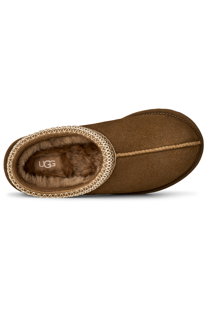 A single brown suede UGG slipper boot with a tan braided trim and brown faux-fur lining, shown from a side profile view on a white background.#color_light-bronze