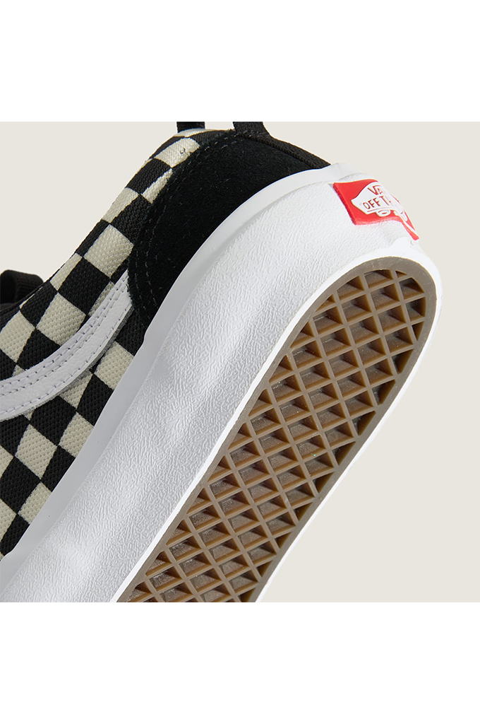 Close-up of a Vans platform sneaker showing the black and cream checkerboard canvas upper, white platform midsole, and brown gum rubber outsole.