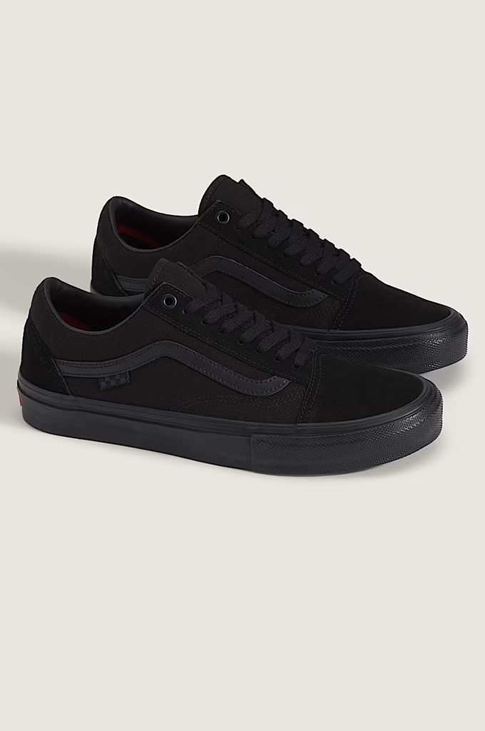 A pair of black low-top Vans sneakers, including the classic Old Skool style, shown on a light beige background.
