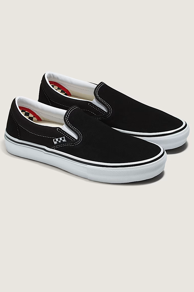A pair of black slip-on platform sneakers with white rubber soles and a small white logo on the side, displayed on a light beige background.